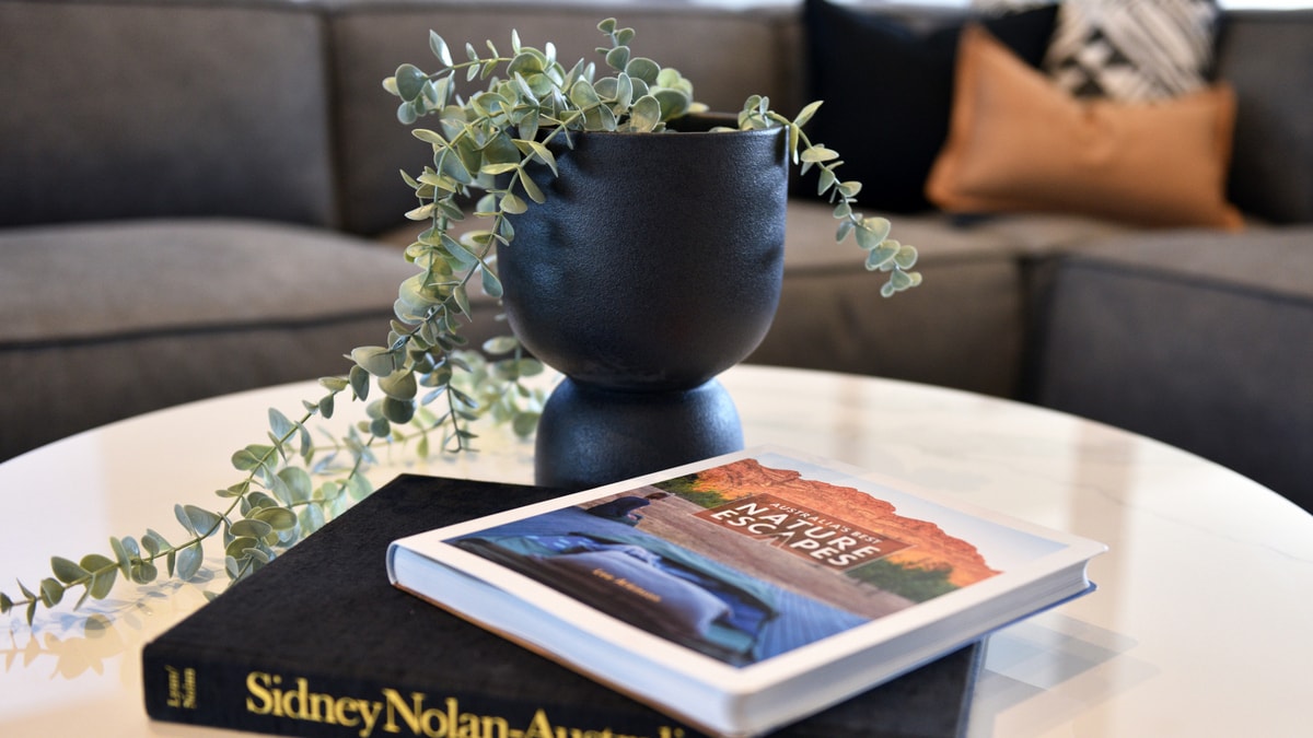 Books beside a black flower vase