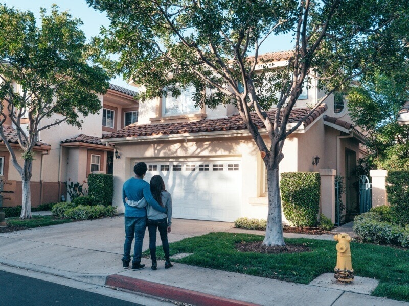 Couple standing in front of their house